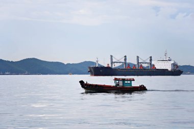 Küçük yolcu denizde çalışan tekne ve kargo gemisi var.