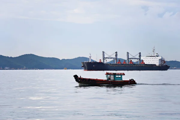 Небольшое пассажирское судно, курсирующее в море и имеющее грузовое судно . — стоковое фото