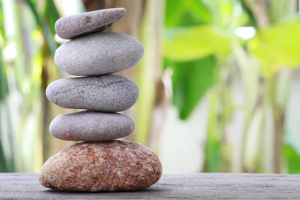 Balance Stones stacked to pyramid in the soft green background.