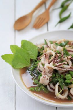 Fesleğenli ahşap zemin üzerinde beyaz tabak kalamar puf.