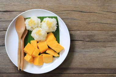 Mango ve yapışkan pirinç beyaz tabak kahverengi ahşap zemin üzerinde ve ha