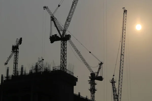 Large construction cranes are building high-rise buildings in th — Stock Photo, Image
