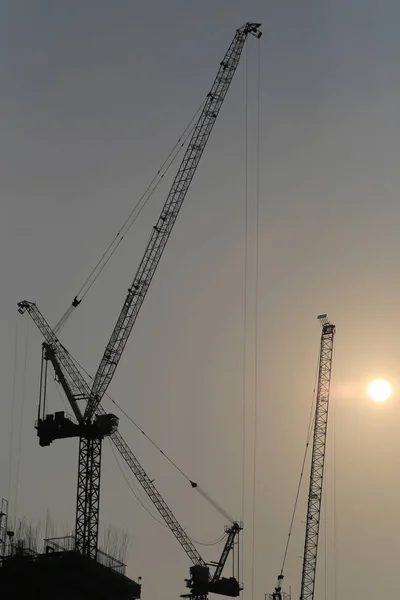 Large construction cranes are building high-rise buildings in th — Stock Photo, Image