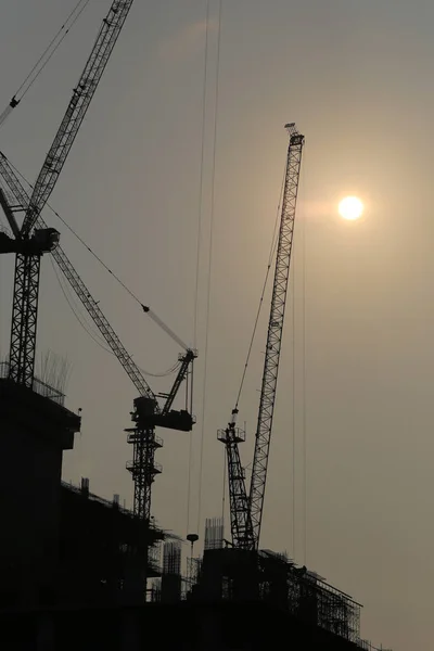 Large construction cranes are building high-rise buildings in th — Stock Photo, Image