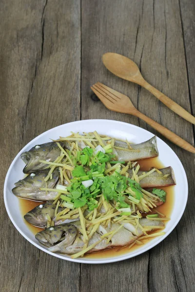 Blue Grouper pescado al vapor de salsa de soja en plato blanco en wo marrón —  Fotos de Stock
