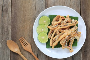 ahşap zemin üzerinde beyaz tabak içinde Tay deniz ürünleri kızarmış kalamar.