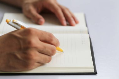 İşadamı elini pap üzerinde nota yazma sarı kalem