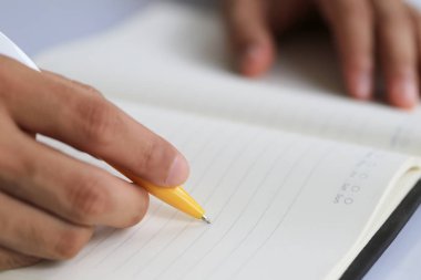 İşadamı elini pap üzerinde nota yazma sarı kalem