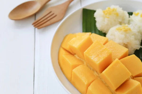 Mango en plakkerige rijst in witte schotel op witte houten vloer en ha — Stockfoto
