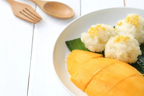 Mango y arroz pegajoso en plato blanco en piso de madera blanca y ha —  Fotos de Stock