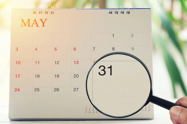 Ampliação de vidro na mão no calendário você pode olhar trinta e um dia — Fotografia de Stock