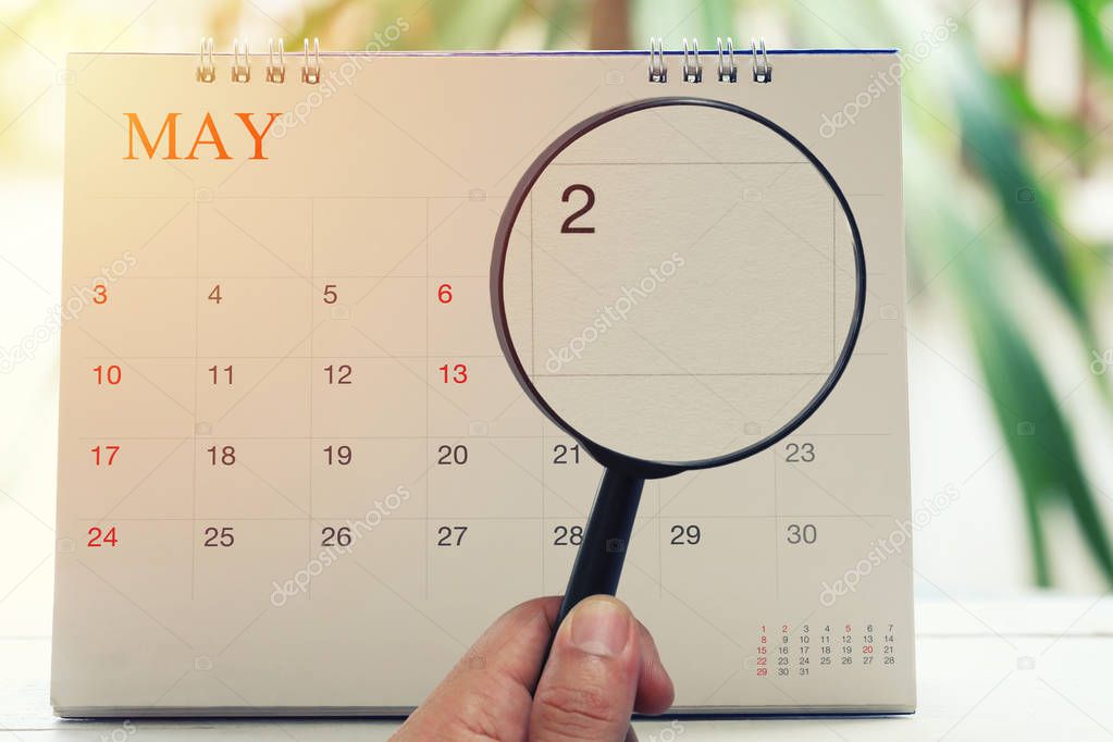 Magnifying glass in hand on calendar you can look second day of 