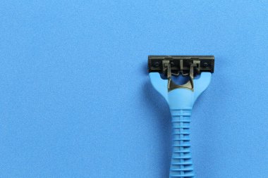 Kırmızı kağıt arka planında mavi jilet.