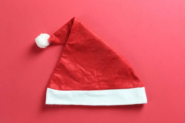 Santa hat on red art paper background.