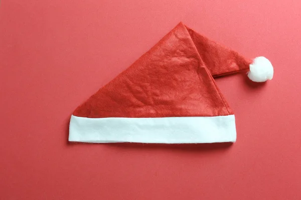 Santa hat on red art paper background.