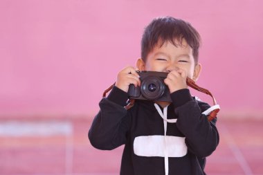 Siyah kamerayı tutan Asyalı çocuk..