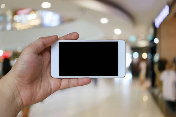 Mano di un uomo che tiene dispositivo smartphone nel centro commerciale bac — Foto Stock