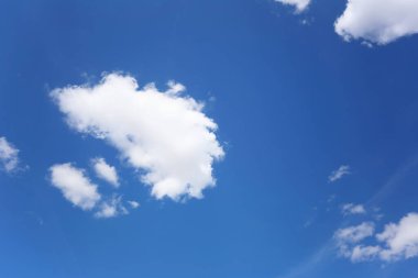 Gündüz arka planda beyaz bulutların olduğu mavi gökyüzü.