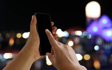 A man's finger pointing to the empty black screen of smartphone.
