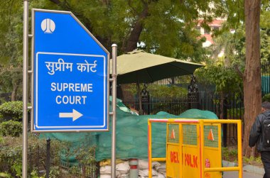 Mavi NDMC yönetim kurulu, Lutyen 'in Delhi' sinin merkezi kısmı olan Patel Marg 'daki Hindistan Yüksek Mahkemesi kompleksine işaret ediyor. Yüksek Mahkeme, ülkedeki en saygı duyulan ve en yüksek adalet mahkemesidir.