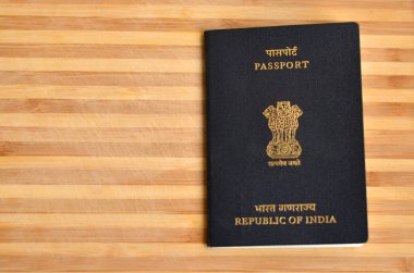 Hindistan pasaportu ahşap arka planda sergileniyor. Hindistan Cumhuriyeti 'nin ulusal amblemi, Sarnath' lı Ashoka 'nın aslan başkentidir. Küresel vatandaş