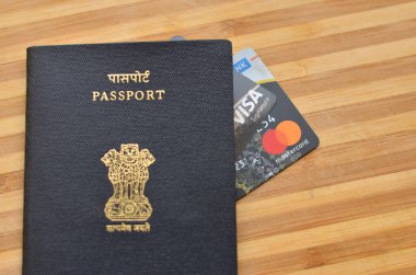 Yeni Delhi, Hindistan, 2020. Hindistan pasaportu, Mastercard ve Visa kredi kartlarıyla ahşap arka planda tutulur. Bu kartlar havaalanı salonlarına ve dünyanın dört bir yanındaki gümrüksüz mağazalardan alışveriş yapmak için kullanılabilir.