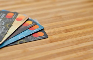 Mumbai, Hindistan, 2020. Tahta arka planda birden fazla MasterCard kredi kartı. Dünya genelinde elektronik fon transferlerini kolaylaştırıyor, çoğunlukla markalı kredi kartları ve banka kartları aracılığıyla.