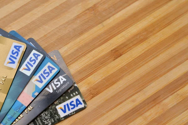 New York, ABD, 2020. Tahta arka planda birden fazla kredi kartı var. Dünya genelinde elektronik fon transferlerini kolaylaştırıyor, çoğunlukla kredi kartları ve banka kartları aracılığıyla.