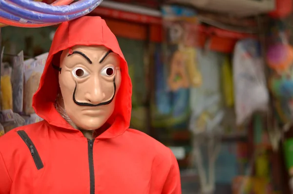 Piyasada popüler İspanyol televizyon dizisi La Casa de Papel veya Para Soygunu 'ndan Salvador Dali maskesi takan birinin portresi. Maske ve kırmızı tulum dünya çapında moda sembolleri.