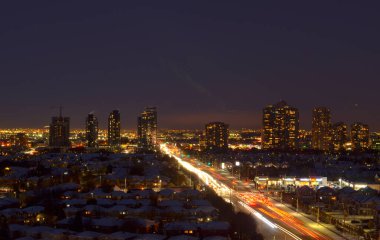 Kuzey Amerika 'daki Mississippi, Toronto, Ontario, Kanada' daki komşu evlerin kar manzaralı çatıları. Akşamları otobanda giden ışık saçan kafa ve stop lambaları.