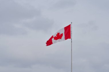 Kanada Ulusal Bayrağı Ottawa, Ontario, Kanada 'da mavi gökyüzüne karşı dalgalanıyor. Fransızcada l 'Unifoli olarak adlandırılan kırmızı alan, merkezinde beyaz kare ve 11 köşeli kırmızı akçaağaç yaprağından oluşur.