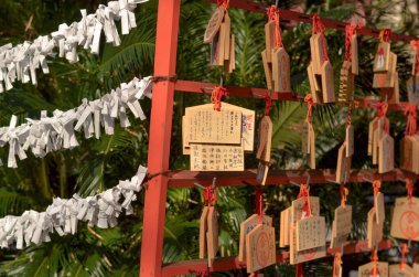 White folded paper with message inside hanging in Japanese temple in rows