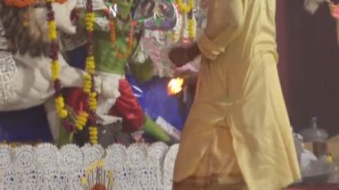 Kolkata, Hindistan, 2020. Dhunachi 'yi elinde tutarak pujo yaparken tütsü saçan ve aarti yapan bir pandit. Kil kap Durga Puja 'da dans ve aarti için, Durga Ma idolü ise arka planda kullanılır..