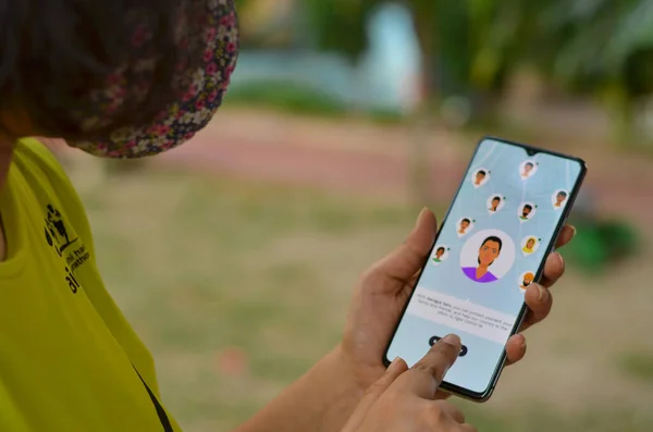 Delhi, Hindistan, 2020. Maskeli kız Aarogya Setu uygulamasını cep telefonuna karantina altına al. Corona virüsü (Covid-19) salgınının önlenmesi ve test edilmesi için Hint govt 'u tarafından başlatılır.