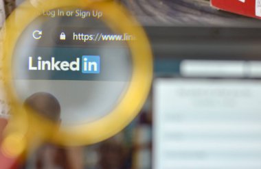 New York, ABD, 2020. Linkedin 'in web sitesi kayıt sayfası büyüteçle açılıyor. Arka planda odak dışı dizüstü bilgisayar ekranı var. Sosyal ağı kabul et