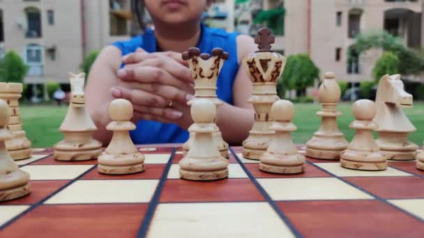 Zpomalený pohyb dívky, která hraje šachy a čeká, až soupeř zahraje, a úzkostlivě přemýšlí o dalším tahu. Koncept - nápad, strategie — Stock video