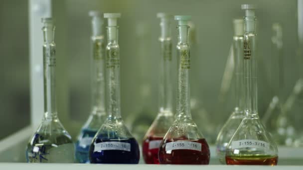 Una variedad de cristalería química con líquidos de colores — Vídeo de stock