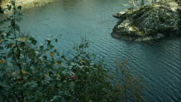 Rotes Floß mit drei Männern auf dem Fjord, vorbei an den Steininseln — Stockvideo