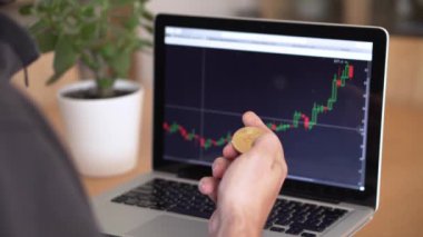 Elinde para tutan ve kripto para tablosunu kontrol eden bir adamın 4k çözünürlüğü