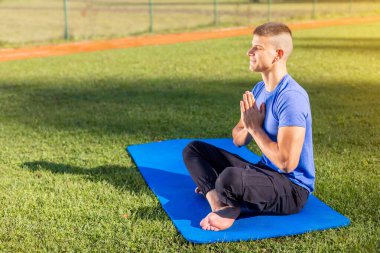 Parktaki adam yoga yapıyor.