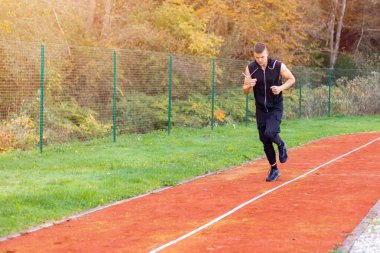 Yarış pistinde koşan adam