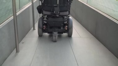 4K çözünürlüklü arka plan. Tekerlekli sandalyede rampa kullanan bir adam. Erişilebilirlik kavramı