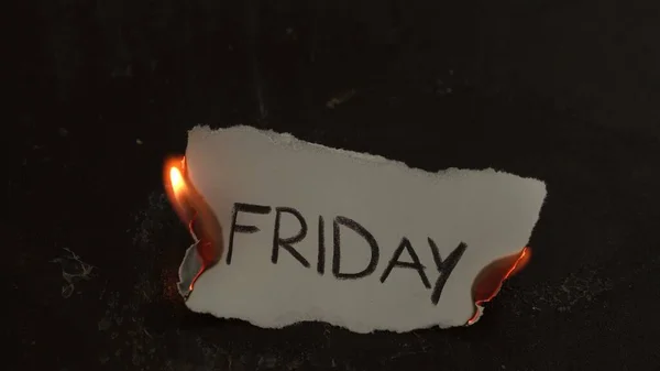 Sexta-feira palavra escrita em queimaduras de papel branco. Fogo com fumaça e cinzas no fundo preto — Fotografia de Stock
