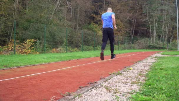 4k nog steeds video van jonge fitte man joggen in de ochtend outdoor op de renbaan — Stockvideo