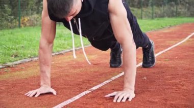 4k pan motion video sabah açık havada koşu pistinde şınav çeken genç adam.