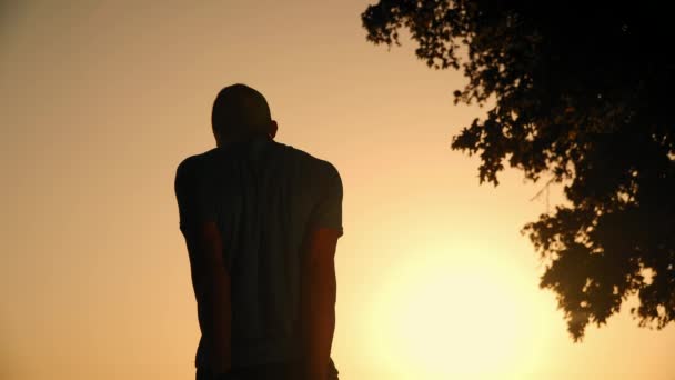 Resolución 4k de un hombre que se calienta con ejercicios antes del entrenamiento intenso al aire libre al atardecer en la naturaleza — Vídeo de stock