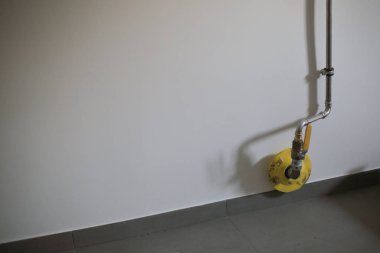 Beyaz duvardaki gaz boruları