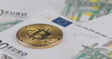 100 Euro 'luk banknotlar üzerinde 4K çözünürlüklü bir Bitcoin altın Bitcoin. Yakın çekim, makro çekim - tava hareketi
