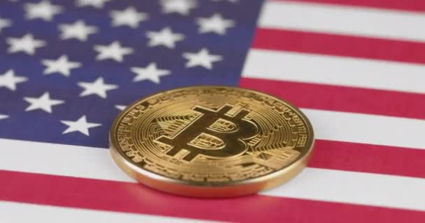 米国、アメリカの国旗に円で回転する4k黄金の暗号通貨Bitcoin — ストック動画