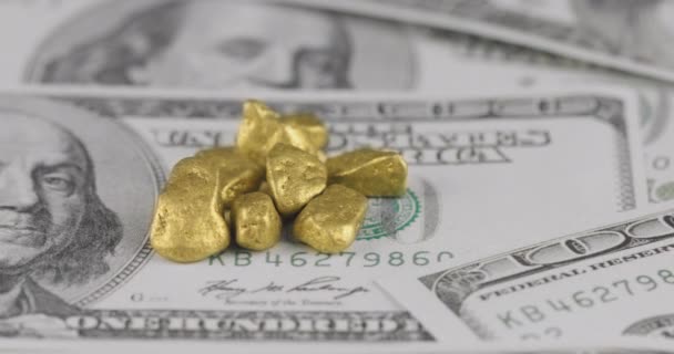 Risoluzione 4k Movimento ravvicinato del mucchio di pepite d'oro adagiate sulle banconote da cento dollari americani — Video Stock